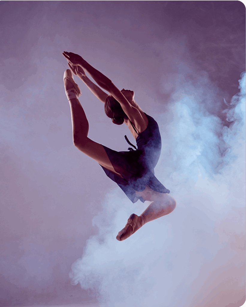 Woman leaping in front of hazy purple background