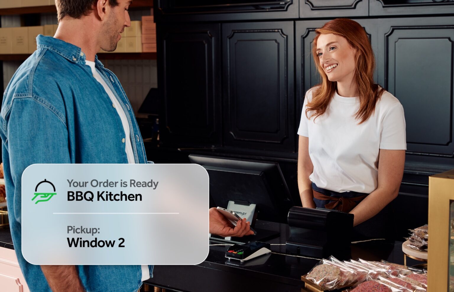 Woman smiling at cash register serving guest