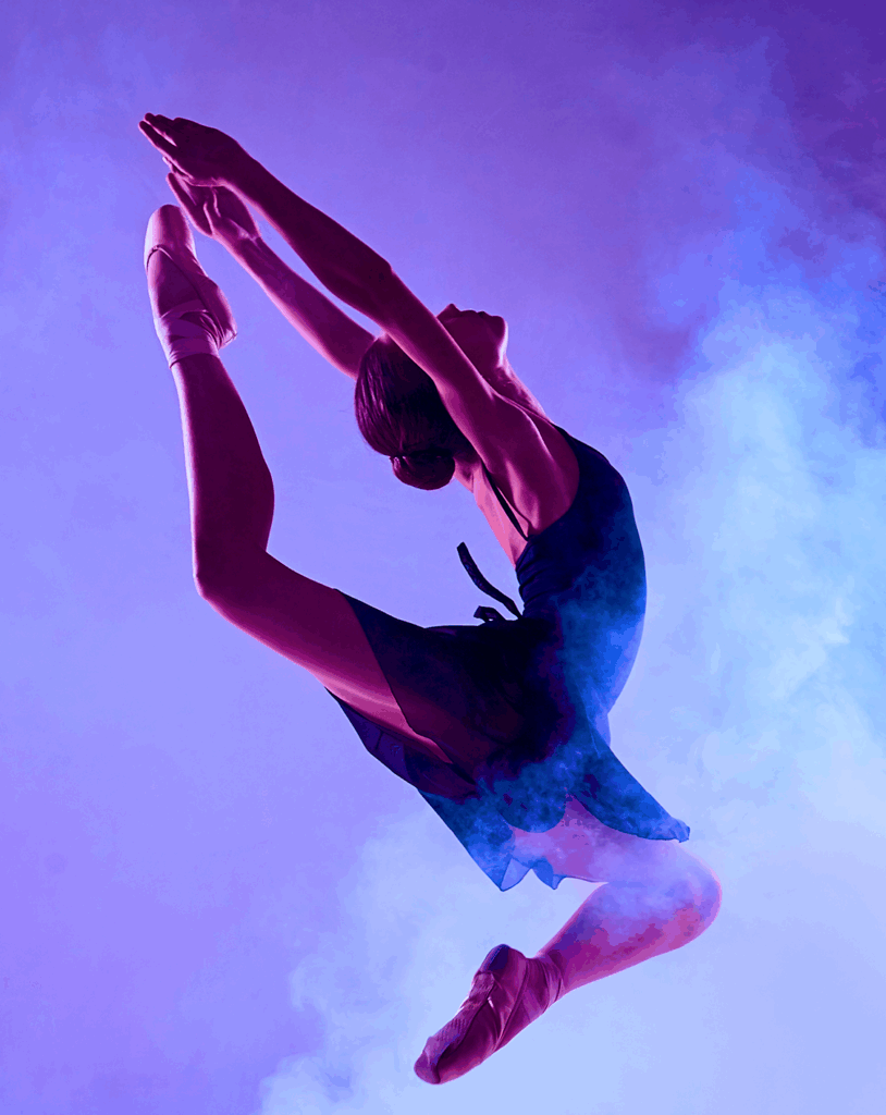 Woman leaping in front of a hazy purple background.