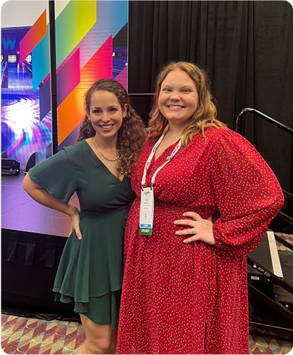 Two women smiling at IAAPA after giving a presentation
