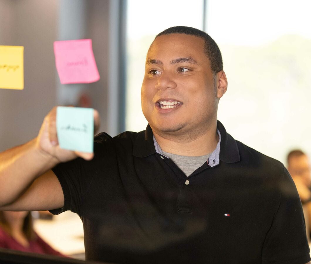 Deion-smiling-using-post-its-for-brainstorm