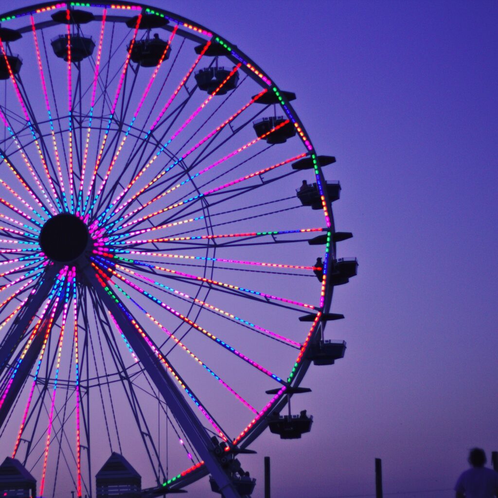 Low Angle View Of Illuminated Ferris Wheel Against Clear Sky At Dusk