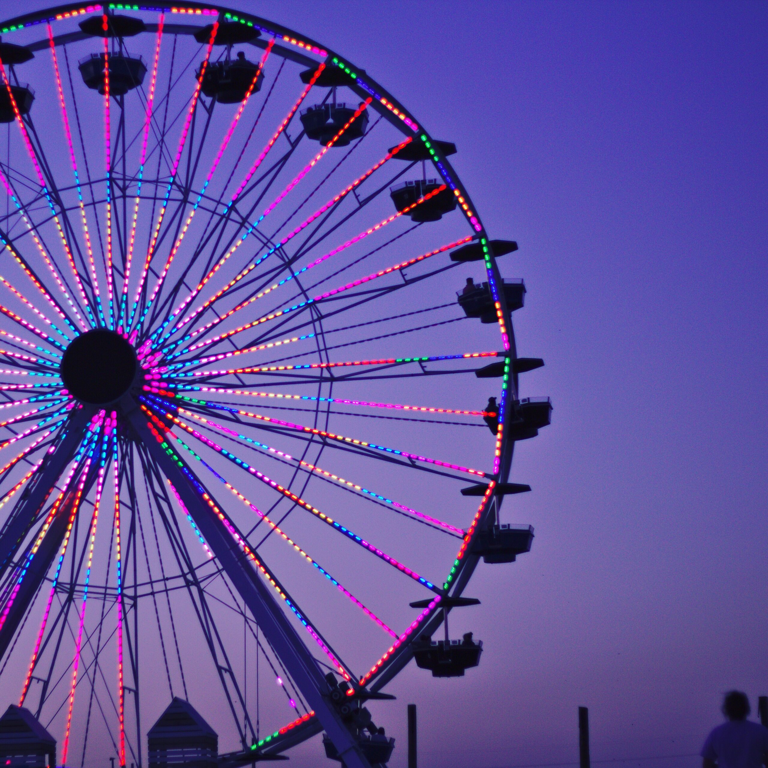 Low Angle View Of Illuminated Ferris Wheel Against Clear Sky At Dusk
