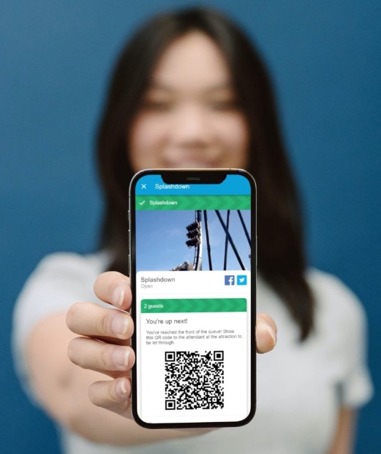 Woman holding a phone up to the camera with QR code
