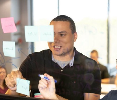 Employee putting post its on a wall.