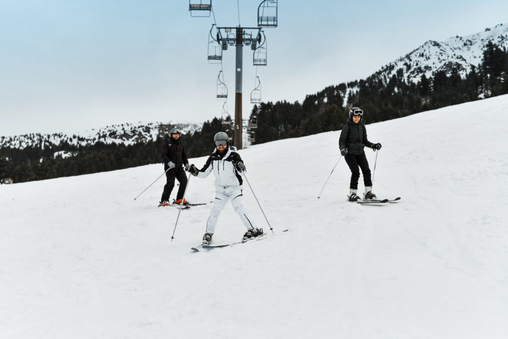 Friends Teaching Male How To Ski