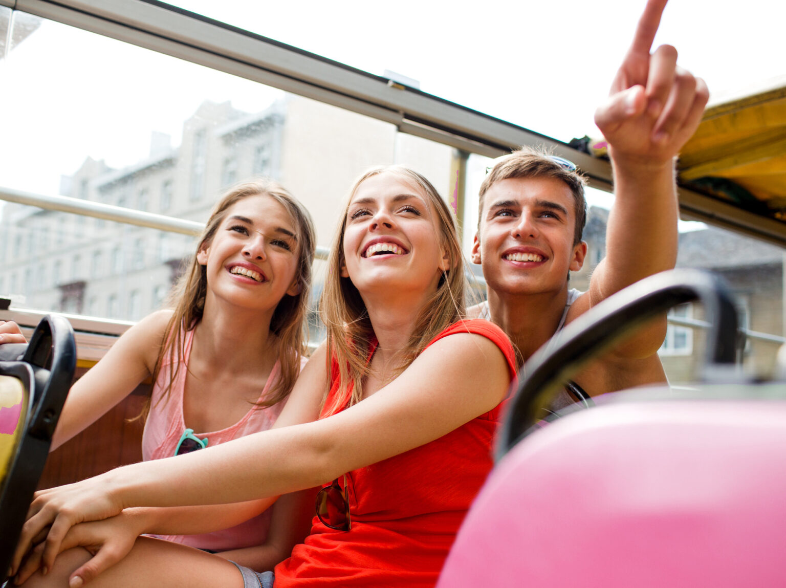 group of smiling friends traveling by tour bus