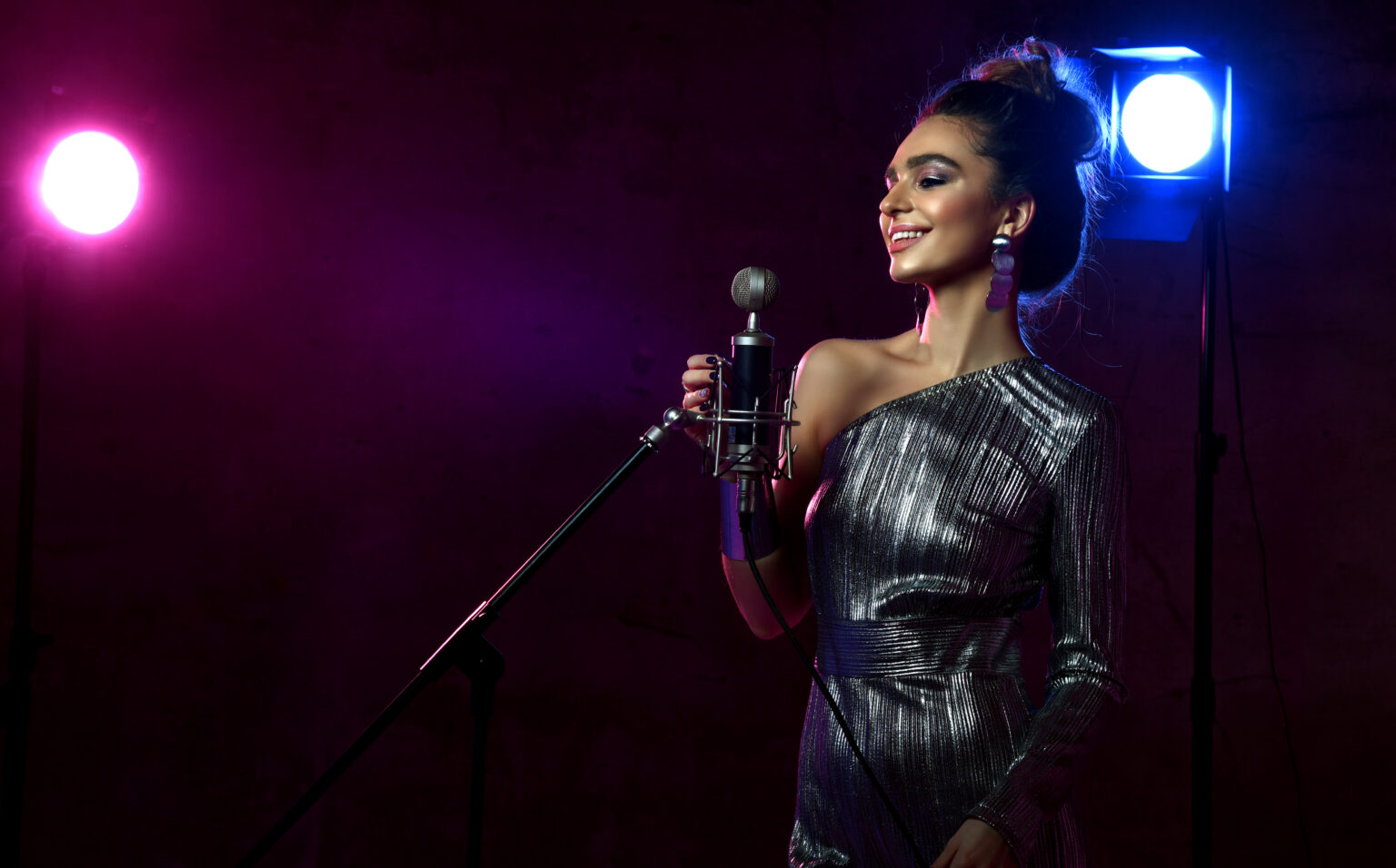 Girl singing with microphone and in front of purple lights