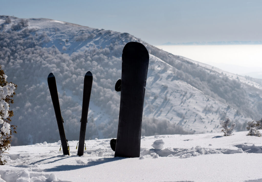 Snowboard and Skis in snow