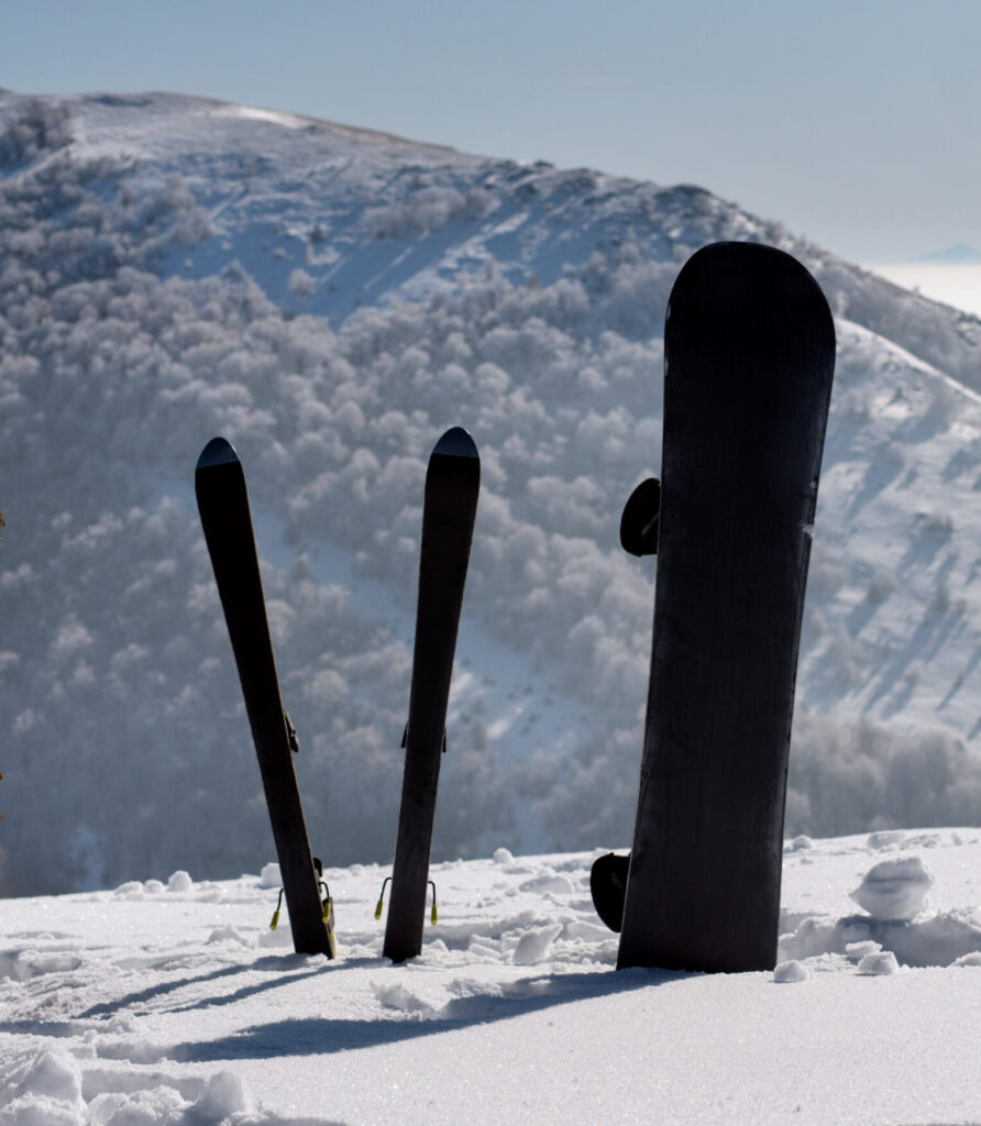 Snowboard and Skis in snow