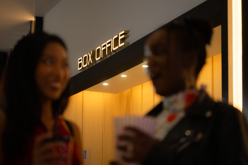 Woman at a box office receiving program
