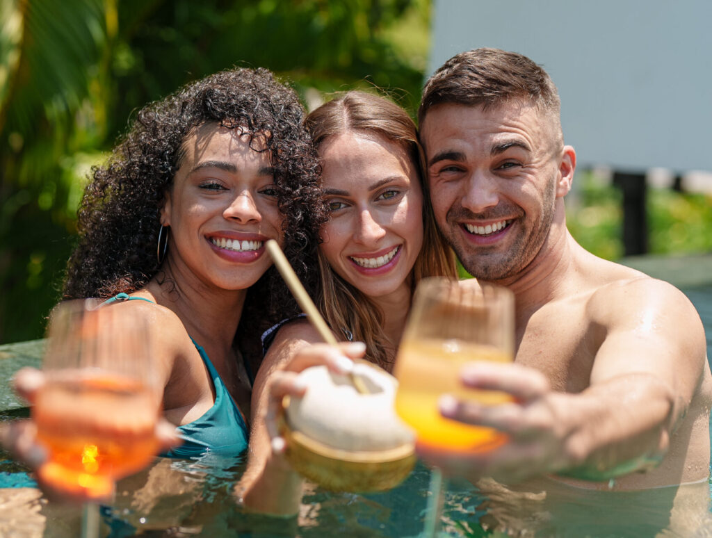 Joyful Friends with Drinks in Pool Enjoyment