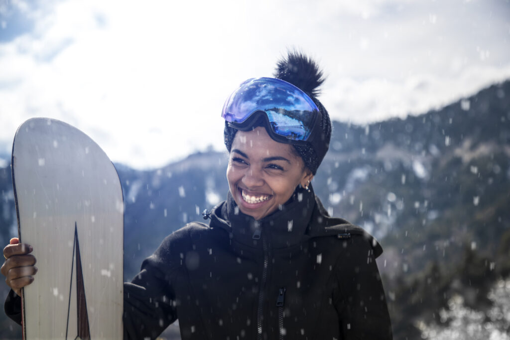 Girl snowboarding and smiling in the snow