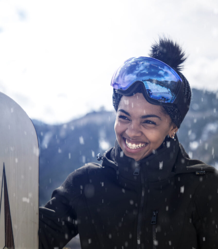 Girl snowboarding and smiling in the snow