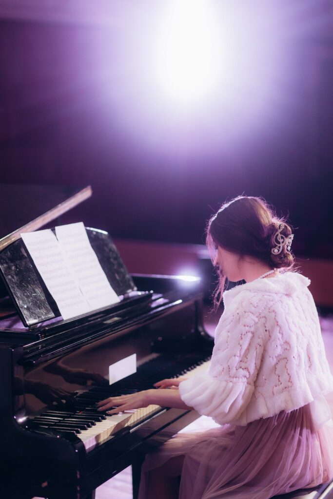 Close up view of a girl plays piano in the concert hall at scene