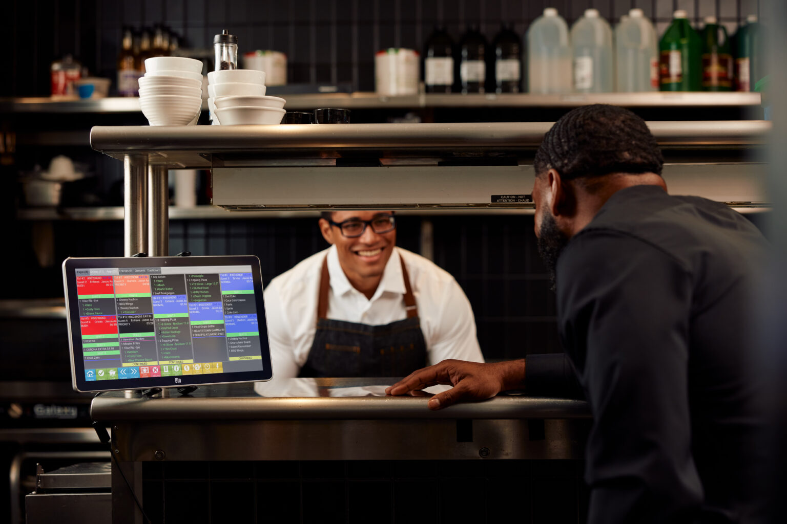 Chef smiling at wait staff from kitchen