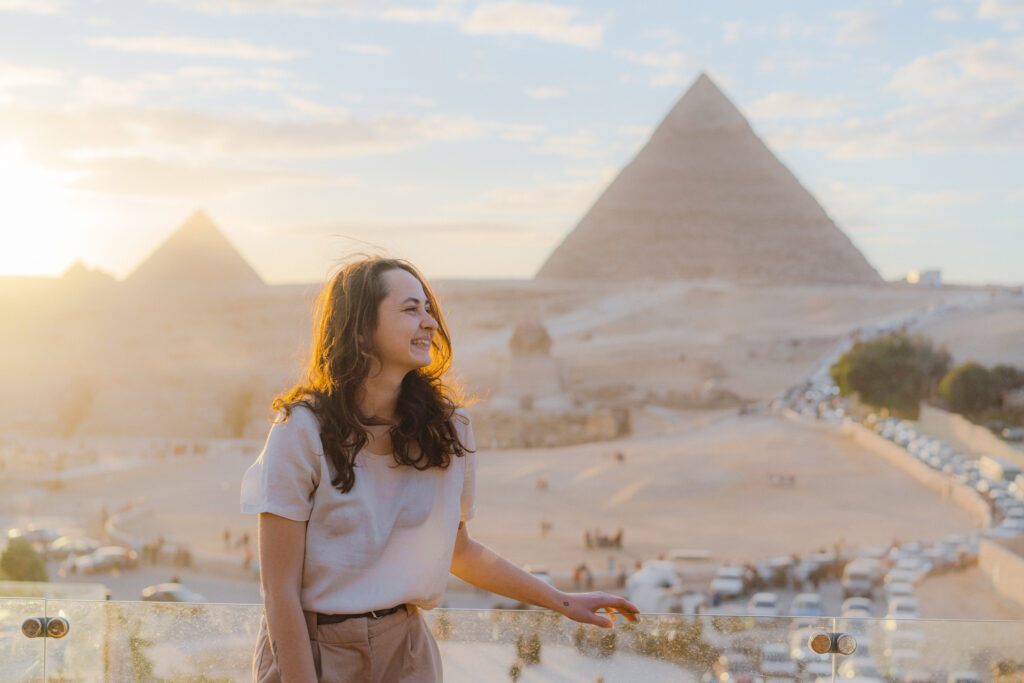 Woman standing on the terrace on the background of Giza pyramids