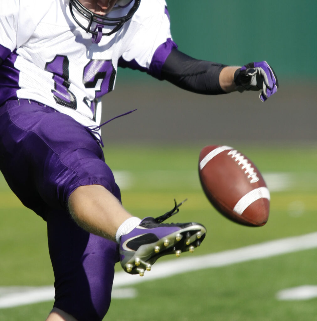 A football kicker punting the ball.