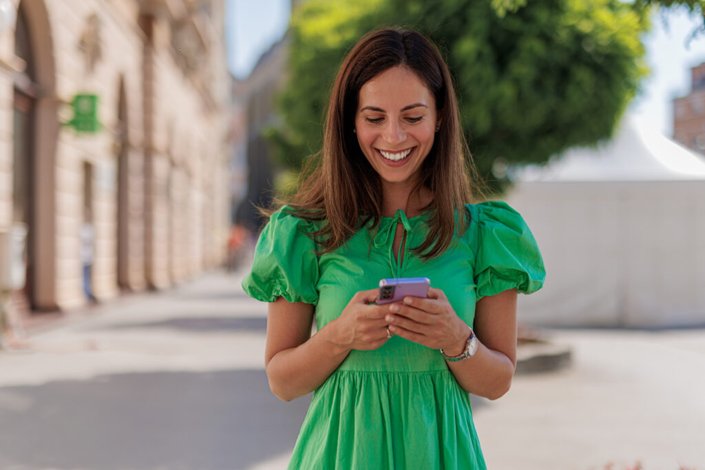 Woman Smiling While Texting on Mobile Phone
