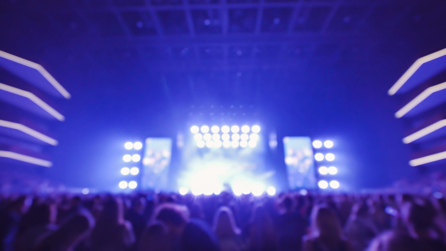 Crowd enjoying live music concert with bright lights at night