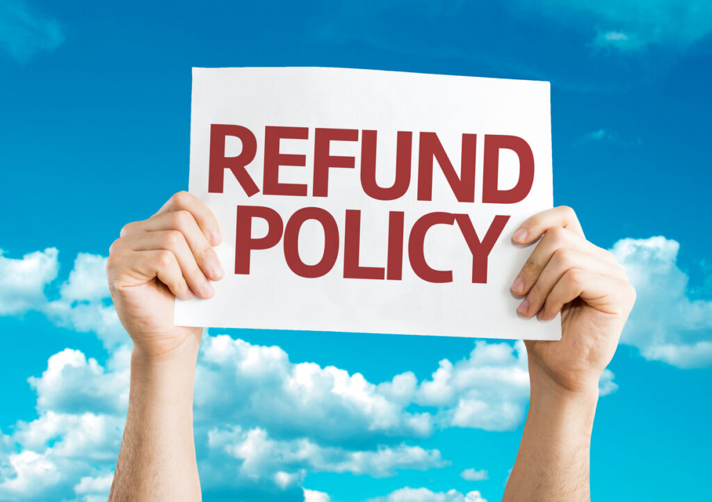Person holding up a refund policy sign